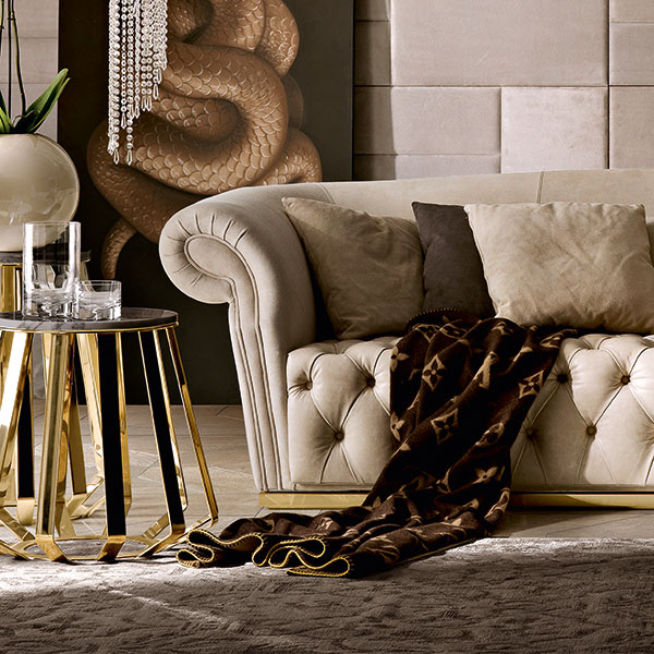 Parete componibile con mosaico in pelle e cornice in legno chiodata<br>
 
<strong>G8903 HERMES</strong><br>
divano con base in acciaio finitura gold   
290 x 120 x 80 cm<br>
 
<strong>GmR07</strong><br>
tavolo in acciaio finitura gold lucidato a specchio, piano marmo cappuccino bisellato lucido
Ø 60 x 53 cm<br>
 
<strong>GmR08</strong><br>
tavolo in acciaio finitura gold lucidato a specchio, piano marmo cappuccino bisellato lucido  
Ø 52 x 63 cm<br>
 
<strong>vss40 Serpente</strong><br>
quadro   
90 x 200 cm<br>
 
<strong>cl5</strong><br>
lampada spirale in cristallo, 12 luci
Ø 40 x 218 cm