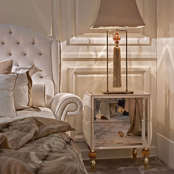 <strong>GL1311</strong><br>
comodino 2 cassetti, fianchi capitonnè, piedini in acciaio finitura gold con sfera in cristallo ambra, completo di pomi ambra  
64 x 45 x 71 cm<br>

<strong>G3043</strong><br>
lampada in acciaio finitura gold con sfera in cristallo ambra e pendente fiocco sfilato, completa di paralume  
30 x 15 x 104 cm